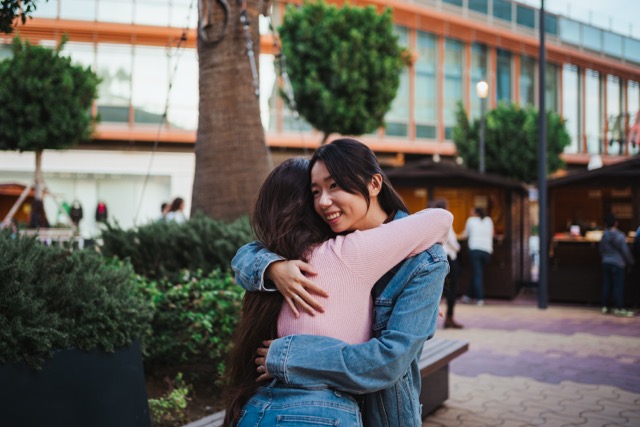 Two young women hugging each other and happy to see each other