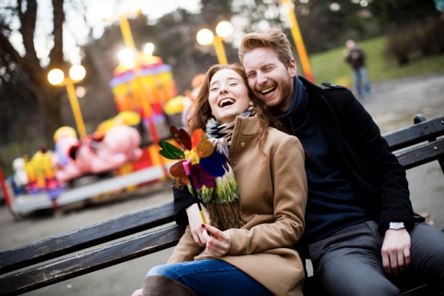 A young married couple is spending their best time at the amusement park.